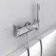 Chromfarbene Badarmatur von Ideal Standard mit Handbrause. Montiert an einer hellen Wand, einfaches Design ohne sichtbare Markenkennzeichnung.